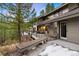 Spacious home exterior featuring a multi-level deck with a lounge area overlooking a wooded backyard at 3816 Spring Valley Trl, Evergreen, CO 80439