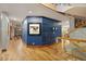 Spacious hallway with hardwood flooring, blue accent wall, and staircase with wood and glass railing at 3816 Spring Valley Trl, Evergreen, CO 80439