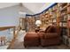 Cozy library with floor-to-ceiling bookshelves, a comfortable chair, and access to an upper-level view at 3816 Spring Valley Trl, Evergreen, CO 80439