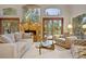 Cozy living room with a stone fireplace, large windows, and access to an outdoor deck at 3816 Spring Valley Trl, Evergreen, CO 80439