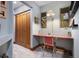 Bright office space with a red desk, chair, and views through two windows, complemented by built-in storage at 3816 Spring Valley Trl, Evergreen, CO 80439