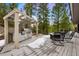 Modern outdoor kitchen with a built-in grill and dining area surrounded by lush trees at 3816 Spring Valley Trl, Evergreen, CO 80439