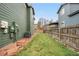 A fenced backyard features a small lawn with a paver stone walkway along the side of the house at 2119 W 101St Cir, Thornton, CO 80260