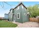 Exterior shot of a two-story home with dark green siding and a grass backyard with a fence at 2119 W 101St Cir, Thornton, CO 80260