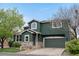 Charming two-story home features a striking dark green exterior with stone accents and a two-car garage at 2119 W 101St Cir, Thornton, CO 80260