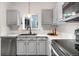 Updated kitchen showcasing gray cabinets, modern appliances, and stylish fixtures at 2119 W 101St Cir, Thornton, CO 80260