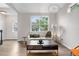 Cozy living room with modern furnishings, hardwood floors, and a large window overlooking the front yard at 2119 W 101St Cir, Thornton, CO 80260
