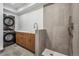 A functional laundry room offers stackable washer/dryer and modern walk-in shower at 964 Quitman St, Denver, CO 80204