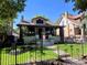 Charming two-story home with a wrought iron fence and lush landscaping at 2725 N Gaylord St, Denver, CO 80205