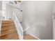 Bright and airy staircase with wood steps and white railings, leading to the upper level at 6183 Xavier St, Arvada, CO 80003