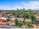 Beautiful aerial shot capturing a neighborhood with lush trees and a stunning city skyline in the background at 1024 34Th St, Denver, CO 80205