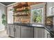 Stylish kitchen featuring exposed brick, floating shelves, stainless steel appliances, and granite counters at 1024 34Th St, Denver, CO 80205