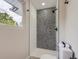 Shower detail in a modern bathroom with black mosaic tile, contemporary fixtures, and natural light at 3793 S Sebring Ct, Denver, CO 80237