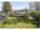 Expansive backyard showcasing a large deck, lush green lawn, and mature trees creating a serene outdoor oasis at 1437 Cassin Ct, Boulder, CO 80303