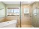 Bright bathroom featuring a soaking tub, a glass shower, and a window that faces the mountains at 1437 Cassin Ct, Boulder, CO 80303