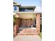 Inviting front entrance with brick pillars, a wooden door with glass inlays, and hanging potted plants at 1437 Cassin Ct, Boulder, CO 80303