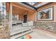 Inviting covered porch with outdoor seating and decorative stone accents at 2202 Dover St, Lakewood, CO 80215