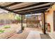Backyard patio with covered pergola, brick and concrete design, and garden beds at 18434 E Belleview Ln, Centennial, CO 80015