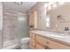 Bright bathroom featuring a shower with tile surround and a wooden vanity with a white countertop at 18434 E Belleview Ln, Centennial, CO 80015