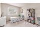 Cozy bedroom with a comfortable bed, a bright window and a bookshelf filled with books and decorative items at 18434 E Belleview Ln, Centennial, CO 80015