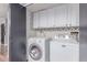 Convenient laundry room with full-sized washer and dryer plus white cabinets for extra storage at 18434 E Belleview Ln, Centennial, CO 80015