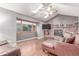 Open living room with brick fireplace, hardwood floors, skylights, ceiling fan, and oversized window at 18434 E Belleview Ln, Centennial, CO 80015