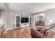 Inviting living room featuring hardwood floors, a large TV, and a stylish entertainment center at 18434 E Belleview Ln, Centennial, CO 80015