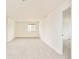 Bright bedroom featuring a neutral carpet, a large window, and a white door at 1477 Serene Dr, Erie, CO 80516