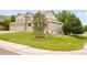 Two-story home featuring a well-manicured lawn with a mature tree at 1477 Serene Dr, Erie, CO 80516
