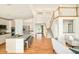 Open-concept living room with hardwood floors, kitchen and access to the front entry at 1477 Serene Dr, Erie, CO 80516