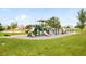 A community playground features multiple slides, climbing structures, and benches at 1477 Serene Dr, Erie, CO 80516