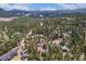 A bird's-eye view shows a house with complementary detached garage, both set among a canopy of trees at 9530 Aspen Ln, Conifer, CO 80433