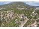 Aerial view showing a cozy home nestled among the trees, offering peace and privacy at 9530 Aspen Ln, Conifer, CO 80433
