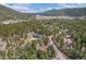 An aerial view of a forested mountain community with a small town in the background at 9530 Aspen Ln, Conifer, CO 80433