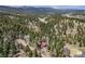 An aerial view captures a home nestled among lush trees, showcasing the privacy and beauty of the surrounding forest at 9530 Aspen Ln, Conifer, CO 80433