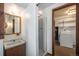 Cozy bathroom with a vanity sink, mirror, shower and laundry area at 9530 Aspen Ln, Conifer, CO 80433