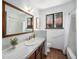 Well-lit bathroom featuring a large mirror, tile countertops, and shower at 9530 Aspen Ln, Conifer, CO 80433