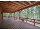 Spacious outdoor deck with wooden railings and stunning views of the forest at 9530 Aspen Ln, Conifer, CO 80433