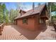 Charming cabin with a spacious deck, wood-paneled exterior, and a unique balcony off the second story at 9530 Aspen Ln, Conifer, CO 80433