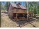The rear exterior of this home offers multi-level decks, mature trees, and attractive wood-paneled siding at 9530 Aspen Ln, Conifer, CO 80433