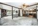 Spacious living room featuring a stone fireplace, wood beam accents, and seamless flow to the kitchen at 9530 Aspen Ln, Conifer, CO 80433