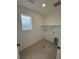 Bright laundry room with a window for natural light and neutral tile flooring at 2145 S Ider Way, Aurora, CO 80018