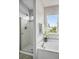 Bright bathroom featuring a glass-enclosed shower, soaking tub, and a window offering natural light at 12411 Irving Dr, Broomfield, CO 80020