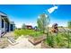 Spacious backyard with garden beds, playset, and ample room for outdoor activities at 59466 E Commanche Way, Strasburg, CO 80136
