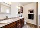 Bathroom featuring double sinks, wood cabinets, decorative mirrors, and ample storage space, perfect for families at 59466 E Commanche Way, Strasburg, CO 80136