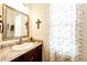 Charming bathroom with a vanity, framed mirror, and a window with sheer curtains, creating a serene space at 59466 E Commanche Way, Strasburg, CO 80136