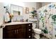 Cozy bathroom featuring a vanity with dark wood cabinets, a decorative mirror, and a shower with a floral curtain at 59466 E Commanche Way, Strasburg, CO 80136