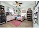 Adorable bedroom with light mint walls, a large bookshelf, and windows overlooking the yard at 59466 E Commanche Way, Strasburg, CO 80136