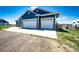 Spacious three-car garage with white doors and brick base, offering ample parking and storage at 59466 E Commanche Way, Strasburg, CO 80136