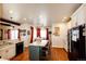 Eat-in kitchen with an island featuring a breakfast bar, light cabinets, wood floors, and abundant natural light at 59466 E Commanche Way, Strasburg, CO 80136